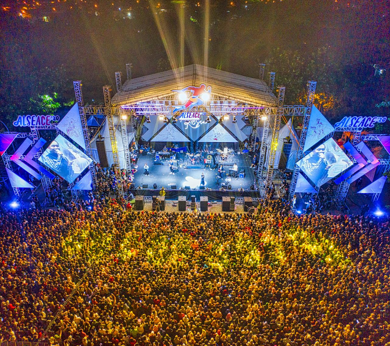 why-choose-us Aerial view of a large crowd enjoying a nighttime concert.